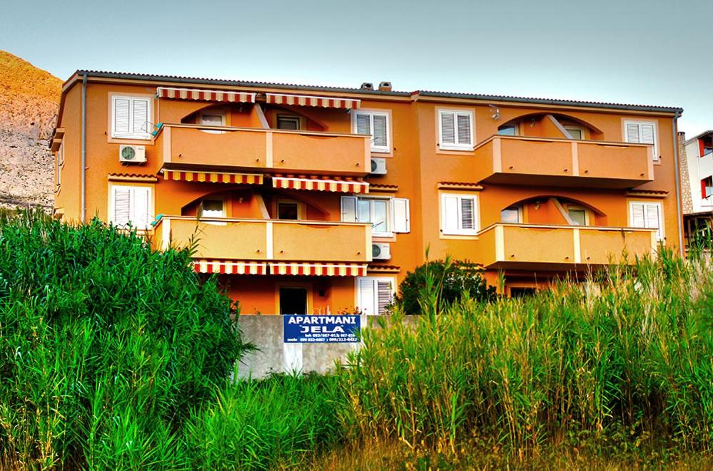 an orange building with a sign in front of it at Apartmani Željko in Metajna