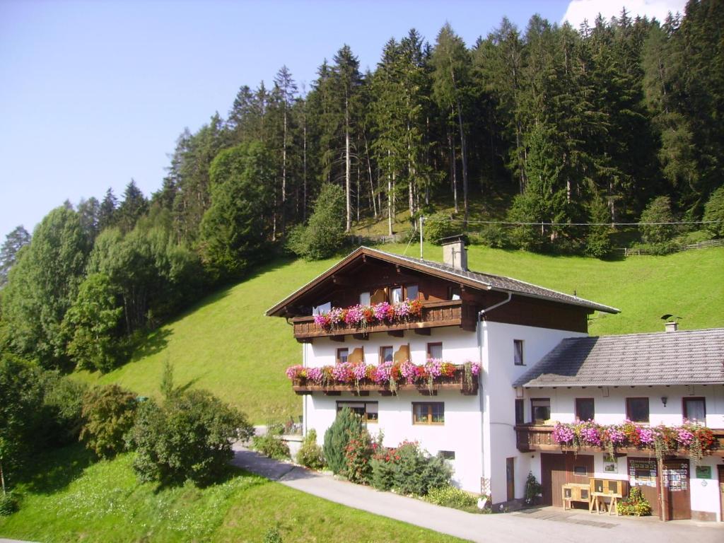 una casa con cajas de flores a un lado. en Alpenbauernhof Gröbenhof, en Fulpmes