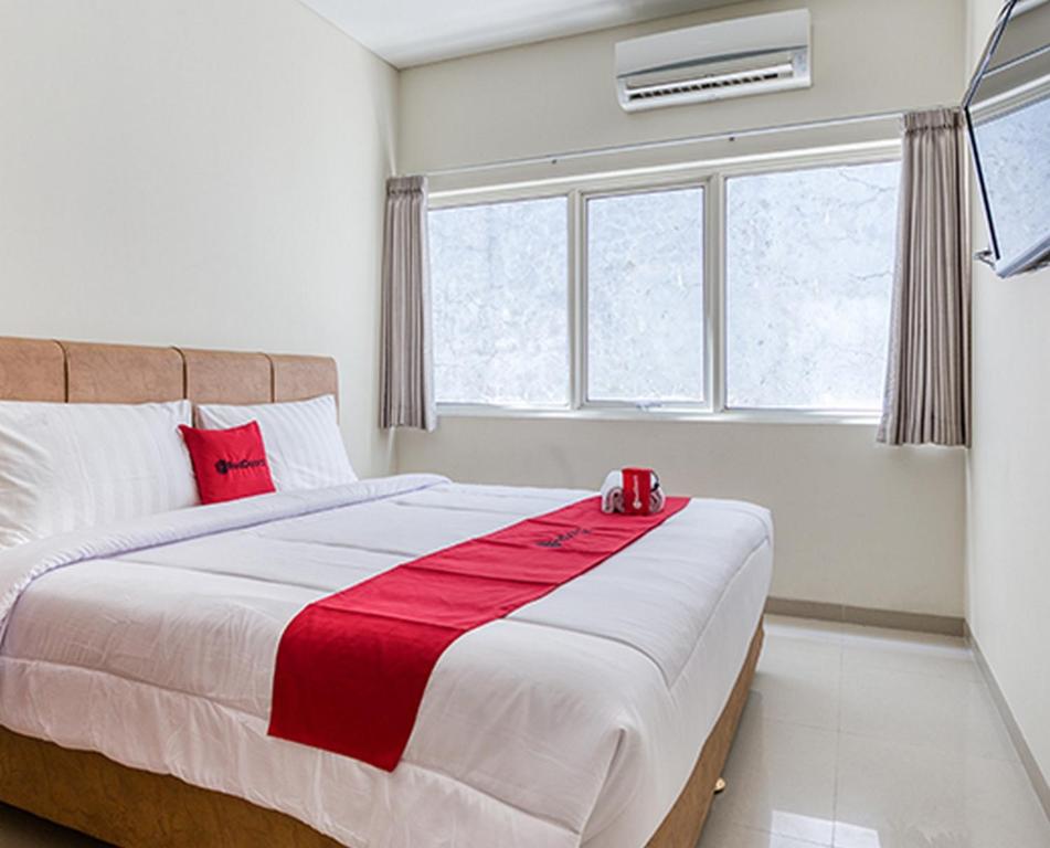 a bedroom with a bed with a red candle on it at RedDoorz near Ciputra World 3 in Surabaya