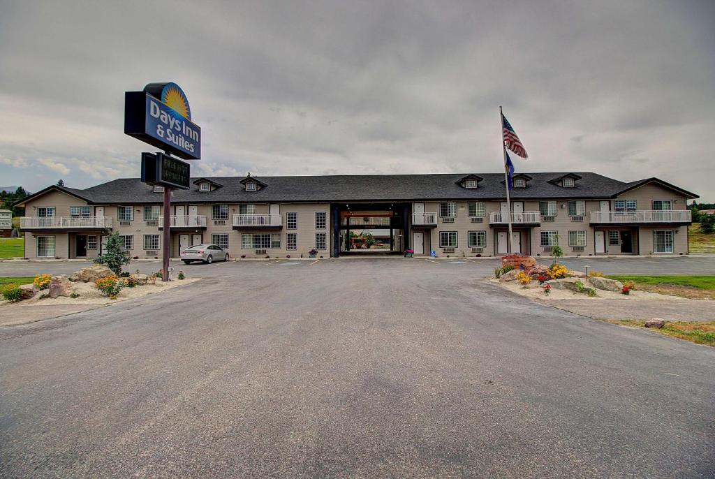 a large building with a sign in front of it at Days Inn & Suites by Wyndham Lolo in Lolo