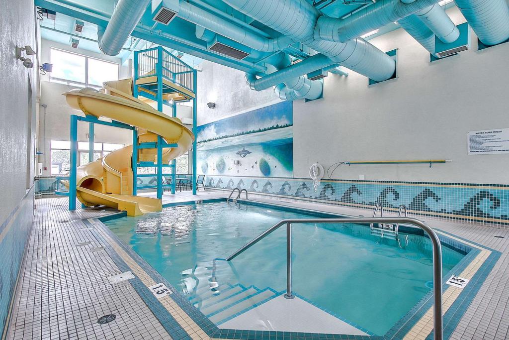 a swimming pool with a slide in a building at Comfort Inn & Suites South in Calgary