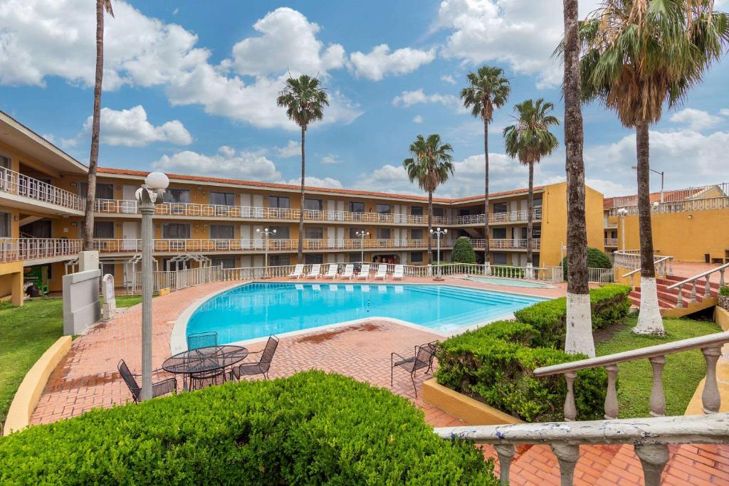 una piscina en un hotel con palmeras en Quality Inn Piedras Negras, en Piedras Negras