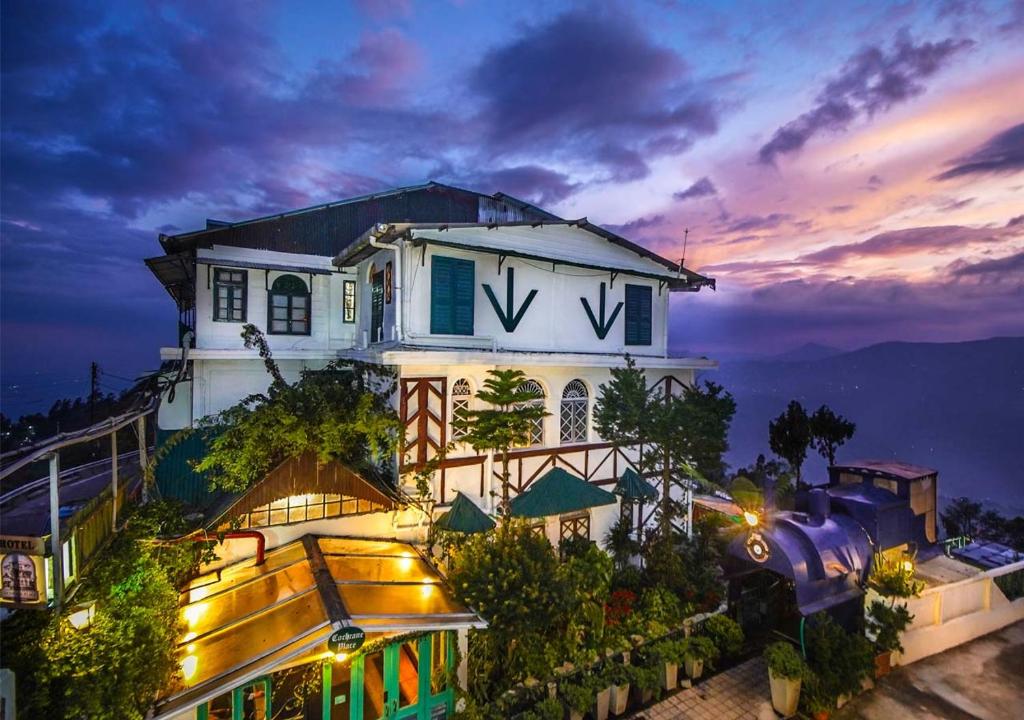 a building with the letter w on it at night at Cochrane Place Hotel in Kurseong