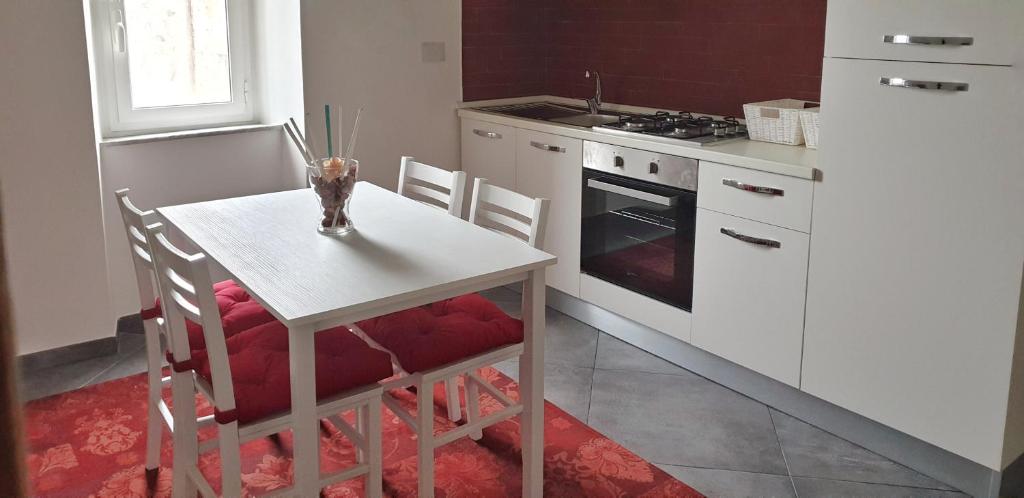 una cucina con tavolo, sedie e piano cottura di La Casa di Alberto a Bolsena