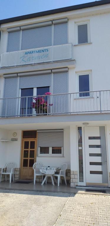 a building with a table and chairs in front of it at Apartments Karmen in Portorož