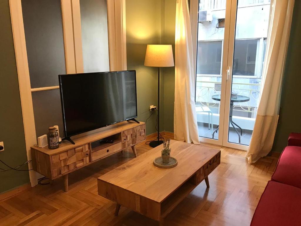 a living room with a flat screen tv and a coffee table at Kanigos 3 BR VIEW Center of Athens in Athens