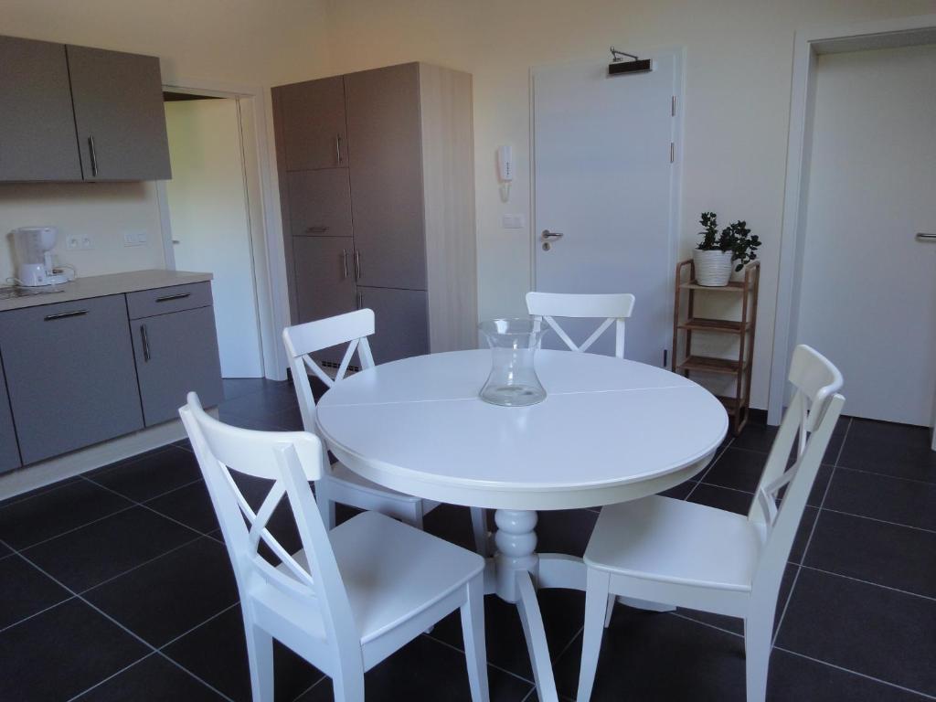 ラ・ロシュ・アン・アルデンヌにあるGite des Evêtsの白いテーブルと白い椅子が備わるキッチン