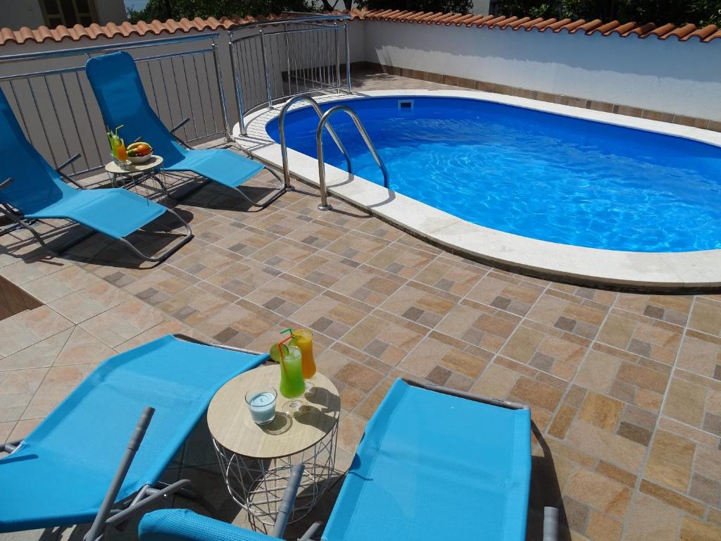 a patio with chairs and a swimming pool at Apartments Lulic in Crikvenica