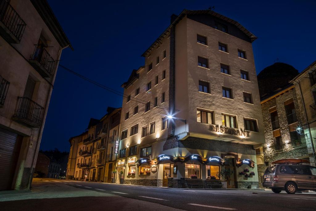 een hoog gebouw in een stadsstraat 's nachts bij Hotel Victor in Rialp