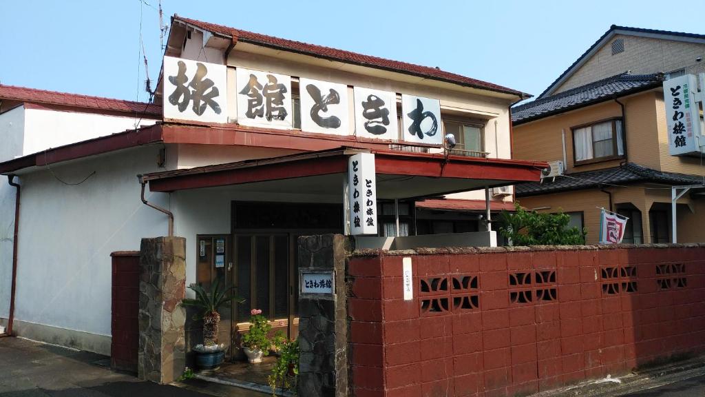 un bâtiment avec des écrits asiatiques sur son côté dans l'établissement Walking Pilgrimage Hotel Tokiwa Ryokan, à Ōzu