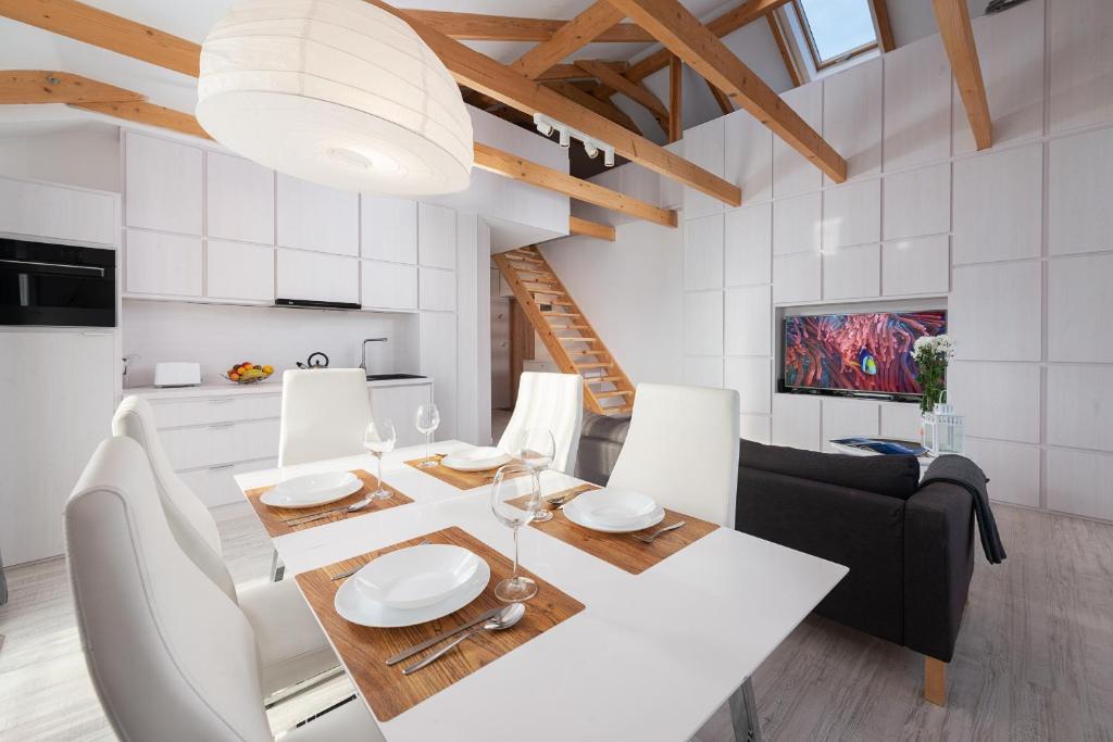 a kitchen and dining room with a white table and chairs at Nowe Apartamenty Puck in Puck