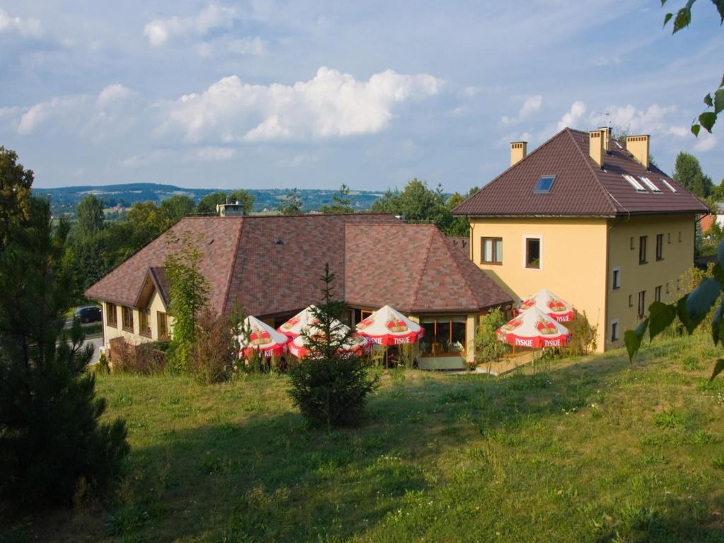 dom na wzgórzu z parasolami na polu w obiekcie Hotel Kochanów w Kochanowie