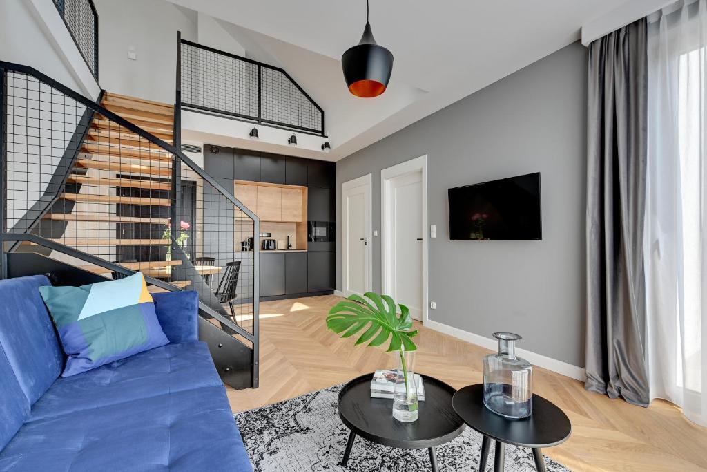 ein Wohnzimmer mit einem blauen Sofa und einem Tisch in der Unterkunft Equus Sopot Apartments in Sopot