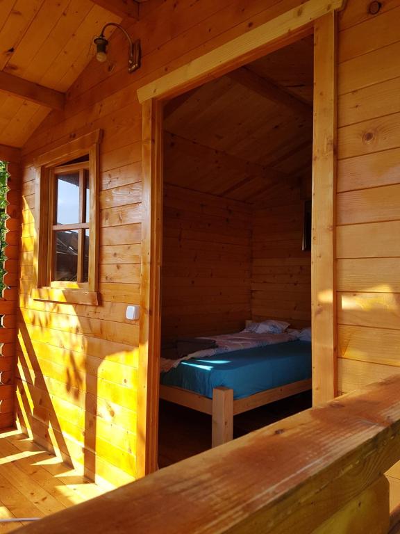 uma cabana de madeira com uma cama dentro em Retezat Retreat - wood cabin em Clopotiva
