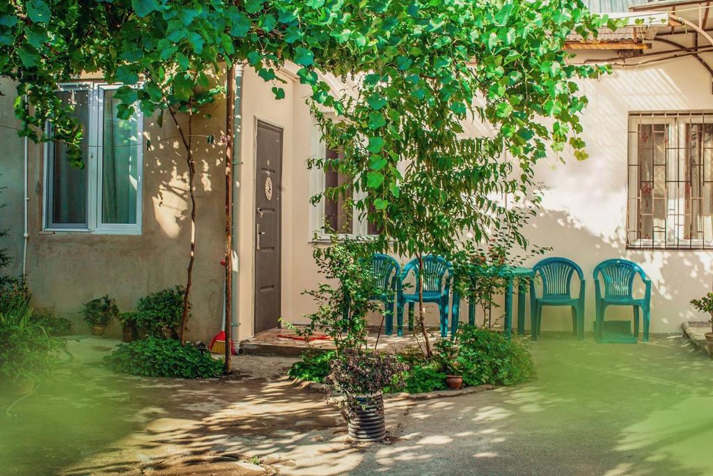ein Haus mit Stühlen, einem Tisch und einem Baum in der Unterkunft Green Corner in Tbilisi City