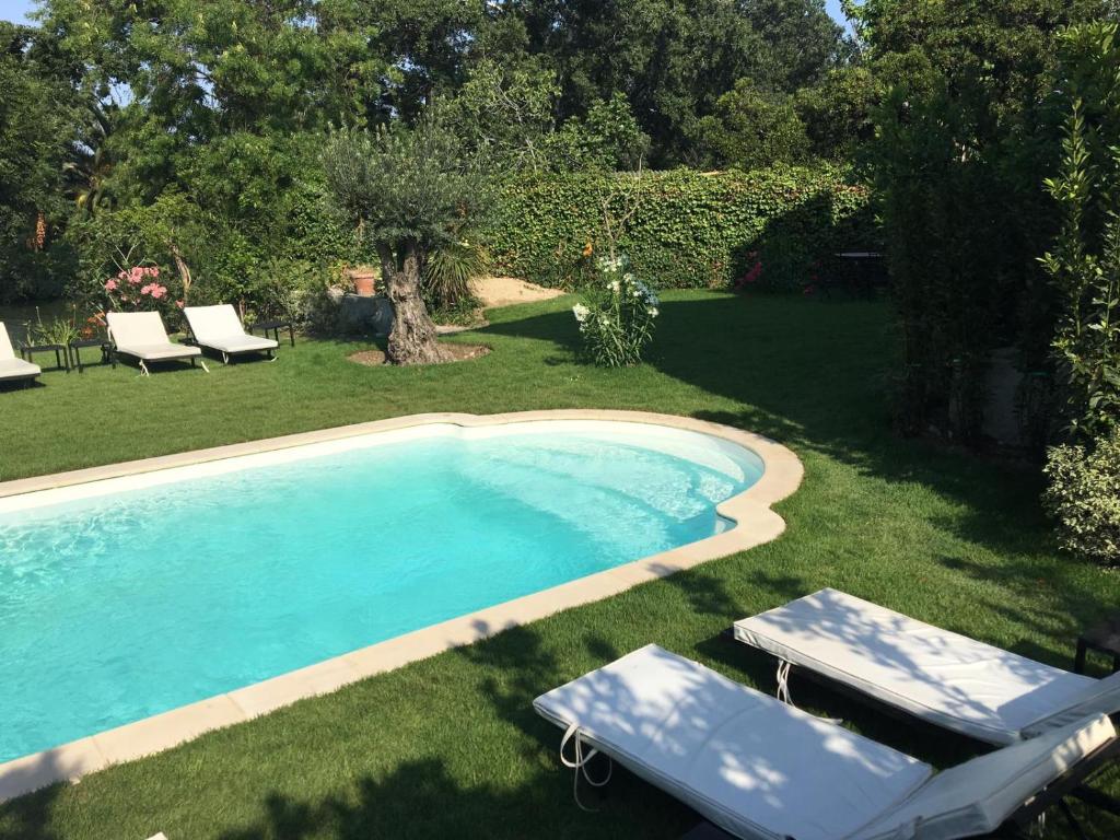 a swimming pool with two lounge chairs next to it at Villa Louise-Rose in Villeneuve-Loubet