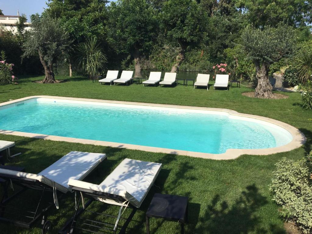 a swimming pool with lounge chairs in a yard at Villa Louise-Rose in Villeneuve-Loubet