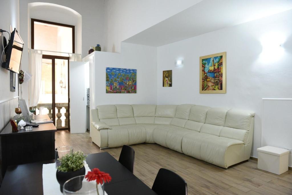 a living room with a white couch and a table at Sisters residence in Bari