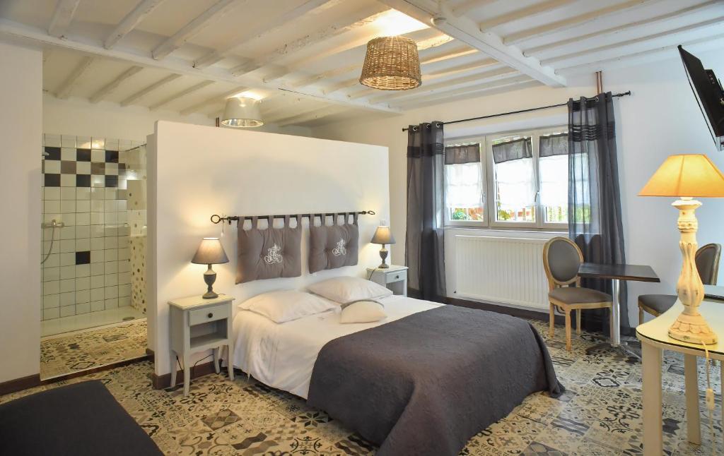 a bedroom with a large bed and a bathroom at Domaine de la Palombe in Villiers-Fossard