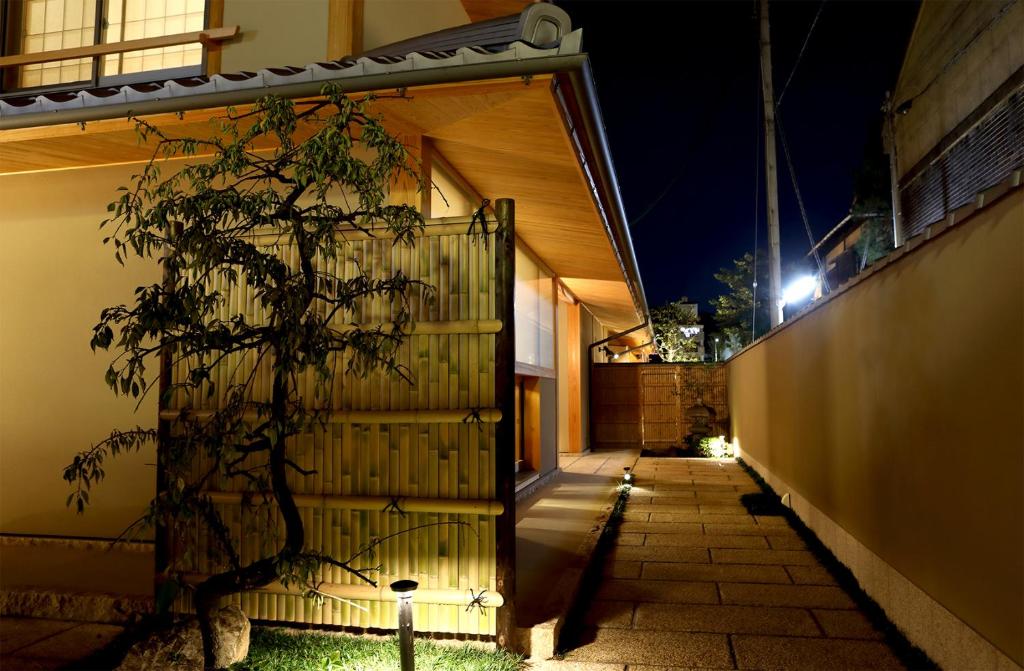 una casa con una puerta y un árbol en el patio en Maru Izumiyacho en Kyoto