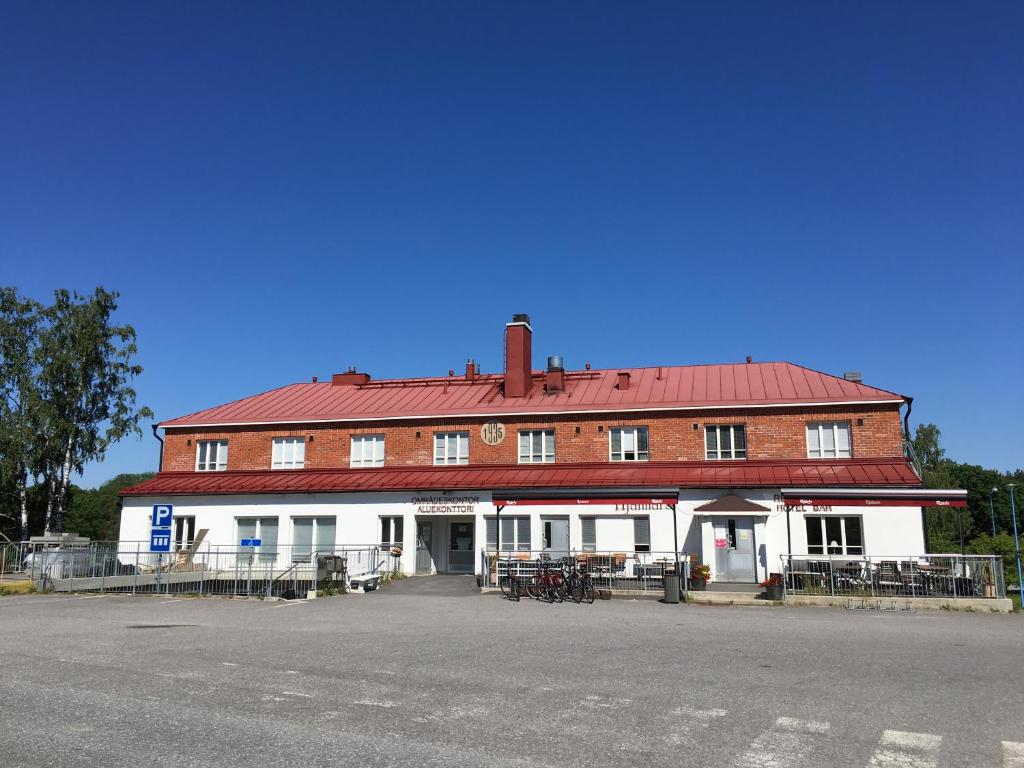 un gran edificio rojo y blanco con techo rojo en Hjalmar’s Hotel, en Korpo