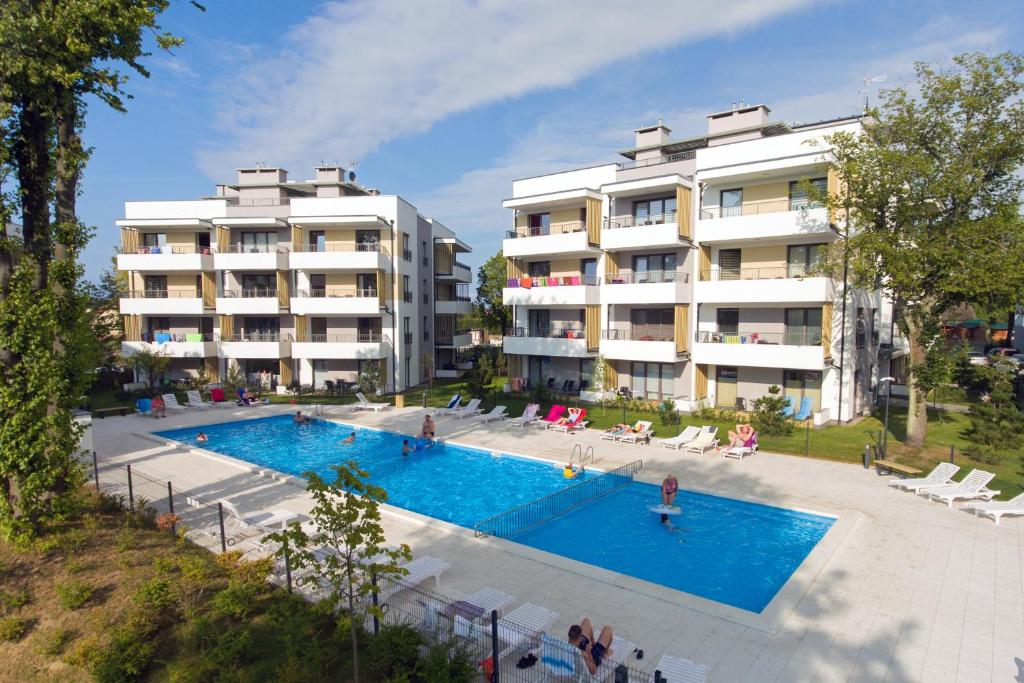 una imagen de una piscina frente a dos edificios en Apartament Morski, en Ustronie Morskie