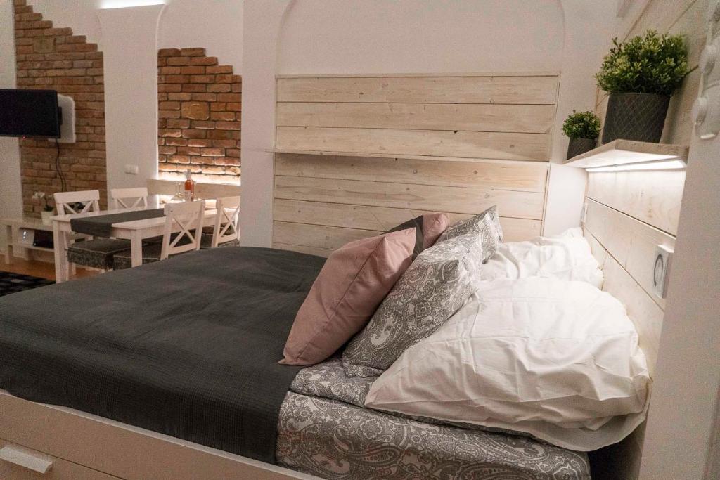 - une chambre avec un lit doté d'une tête de lit et d'oreillers dans l'établissement O&B Apartman, à Budapest