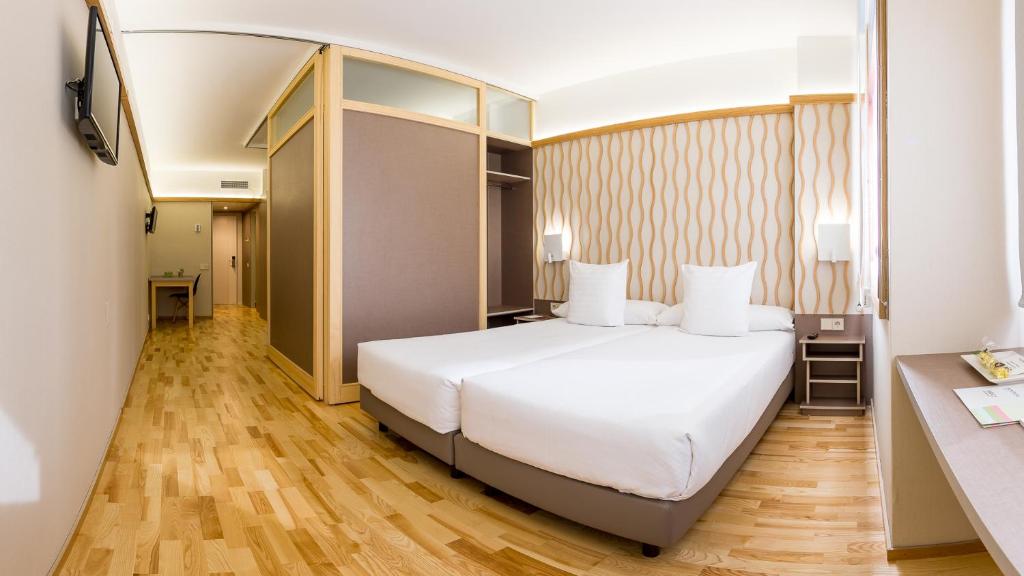 een slaapkamer met een wit bed en een bureau bij Bonanova Suite in Barcelona