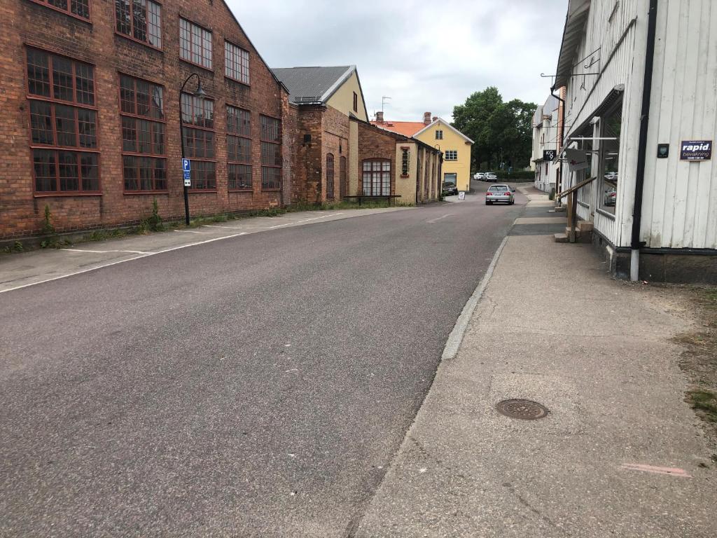 an empty street next to a brick building at Hattkalles Vandrarhem in Smedjebacken