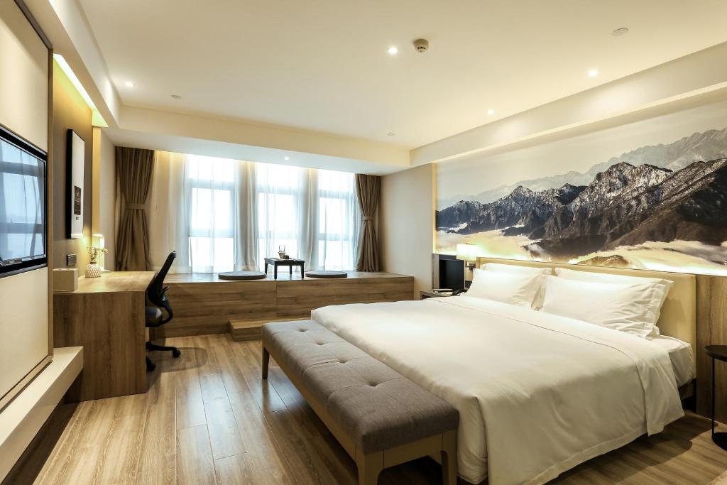 Atour Hotel Chengdu Shuangliu International Airport في تشنغدو: غرفة نوم مع سرير أبيض كبير ومكتب