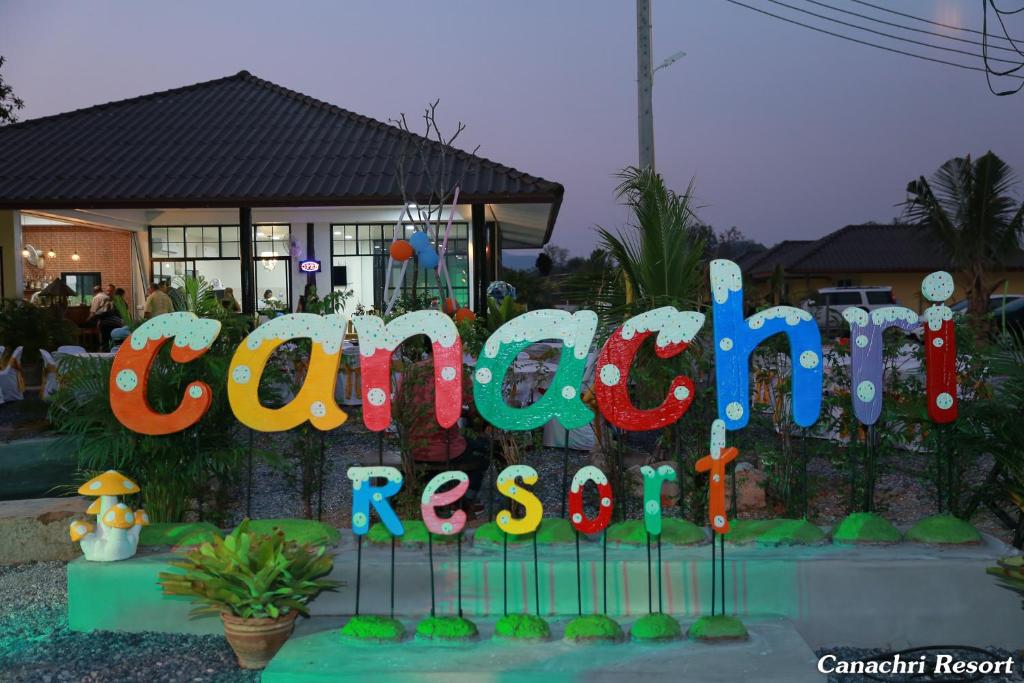 um sinal colorido para uma festa em frente a uma casa em Canachri Resort em Ban Thung Pho