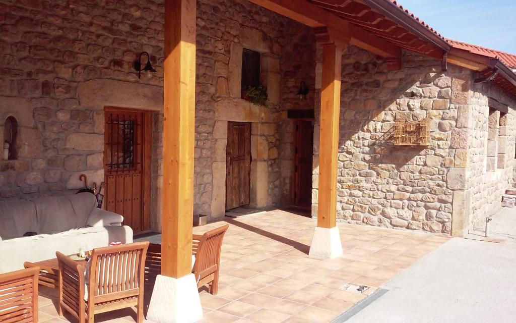 Casa de piedra con porche con sofá y sillas en Naturaleza playas y montañas en Cabezón de la Sal