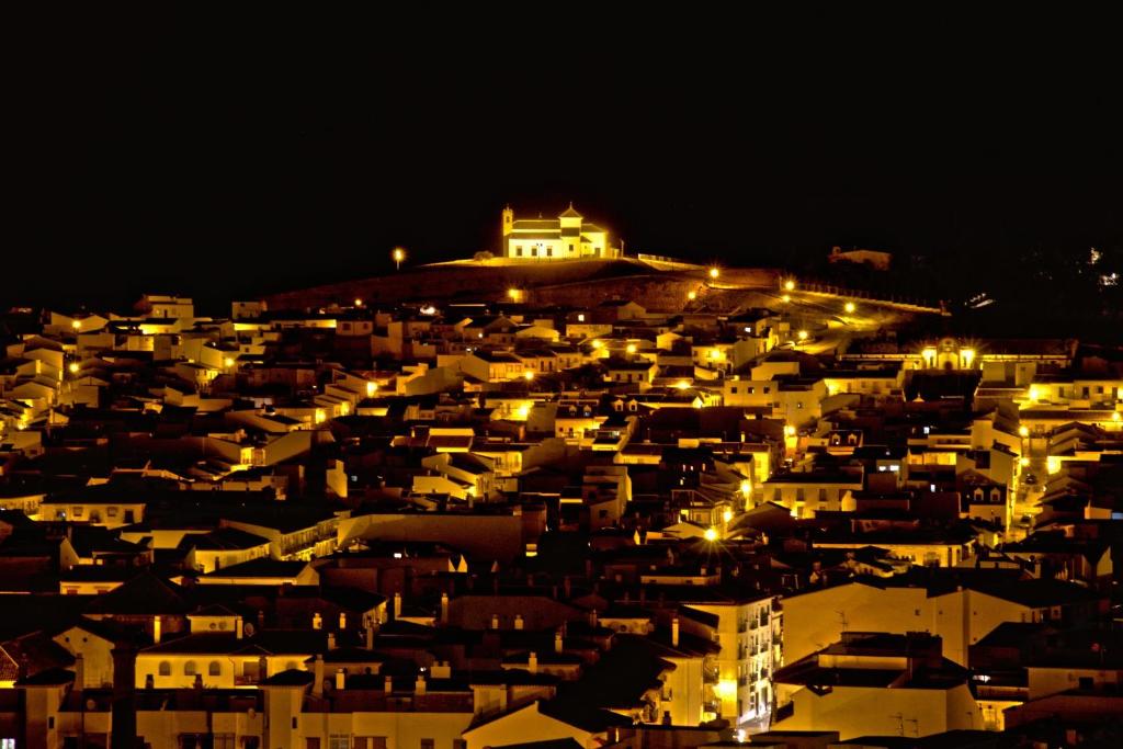 a city lit up at night with a castle in the background at Los Dólmenes in Antequera
