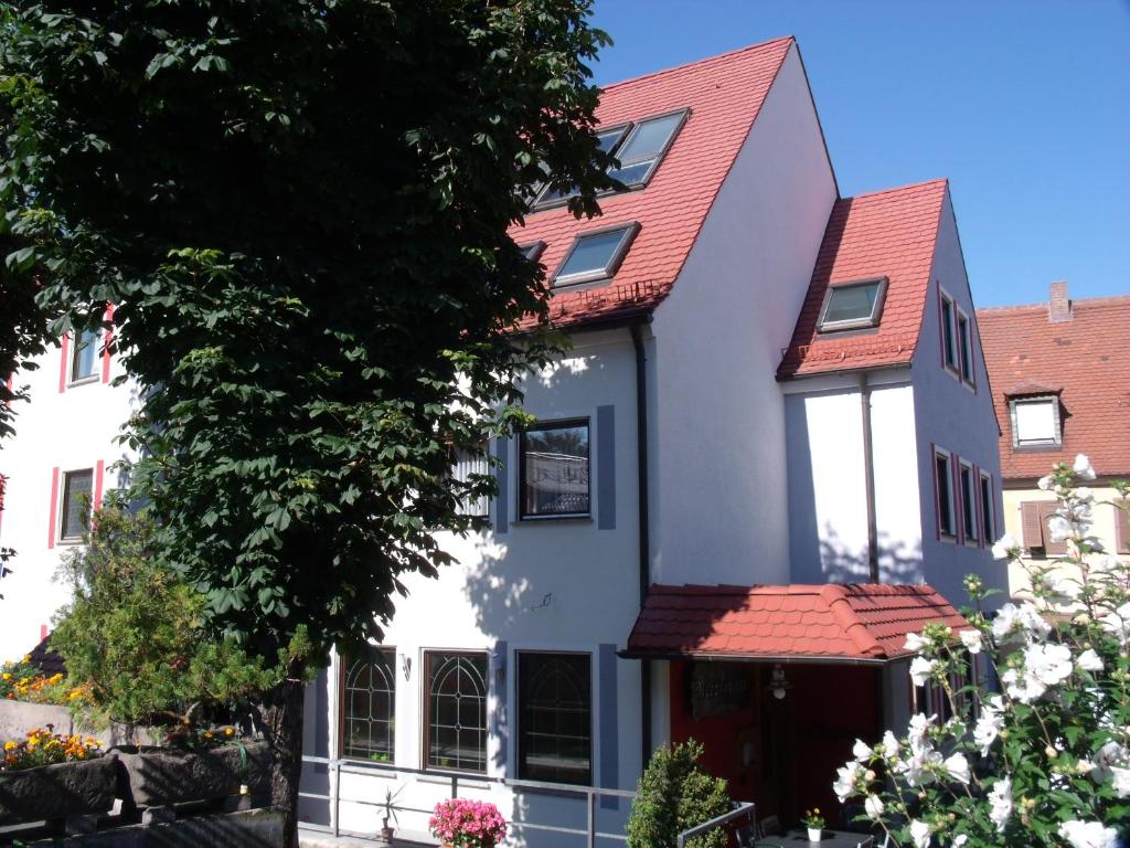 ein weißes Haus mit rotem Dach in der Unterkunft Hotel Brehm in Würzburg