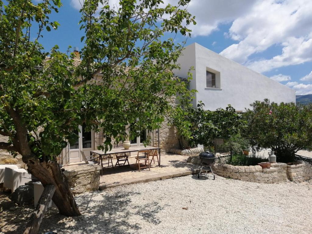 ein weißes Haus mit einem Picknicktisch und Bäumen in der Unterkunft Poggio del Gallo in Chiaramonte Gulfi