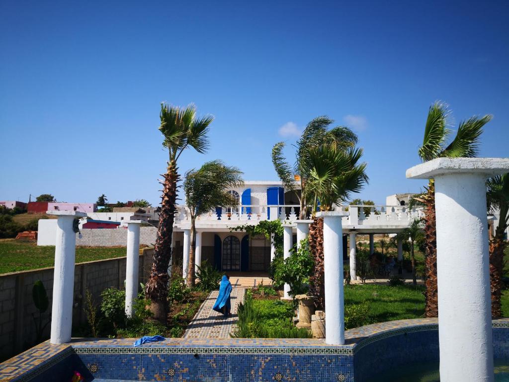 a house with palm trees in front of it at RIAD DES OISEAUX in El Aouamra