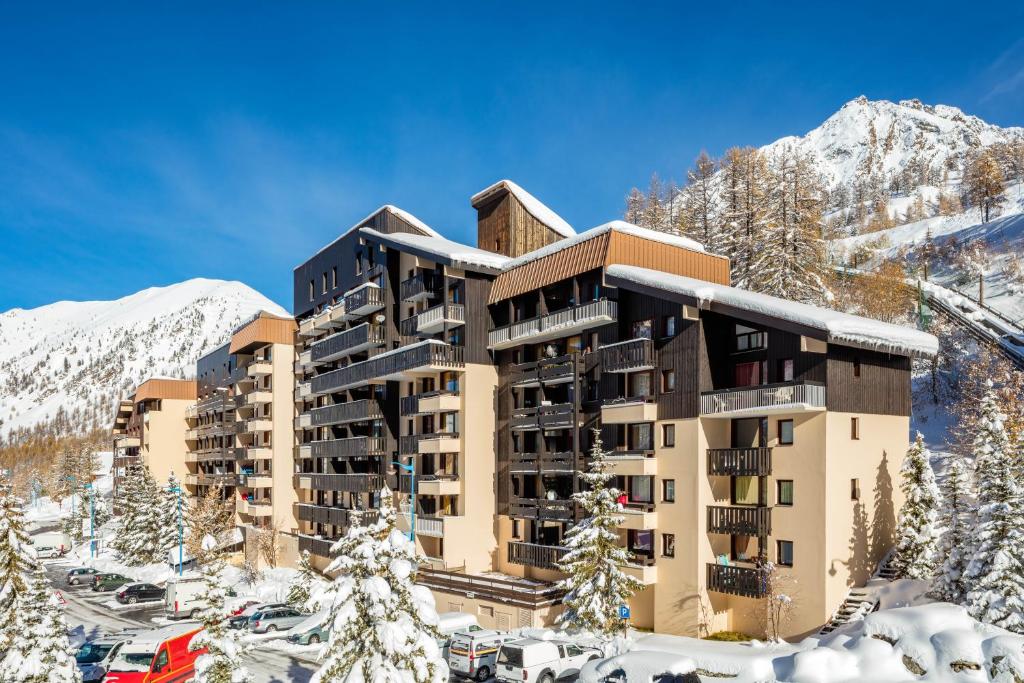 un hotel en las montañas cubierto de nieve en Résidence Capfun Les Adrets, en Isola 2000