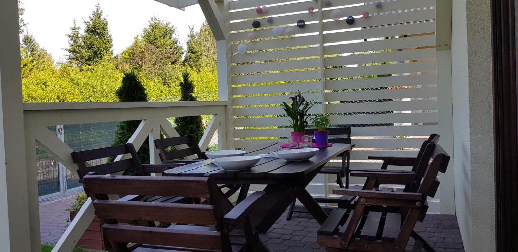 a table and chairs on a patio with a white pergola at Domki letniskowe,apartamenty Wczasowa 8a in Sianozety