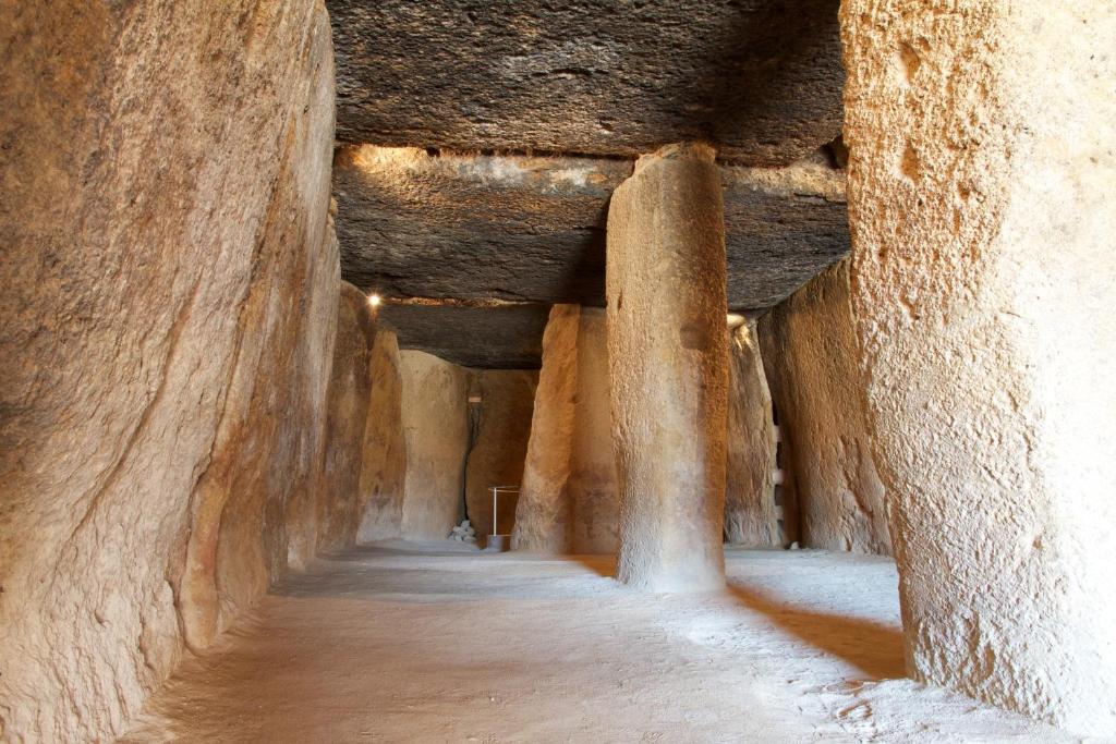 a hallway in a stone building with columns at Los Dólmenes in Antequera