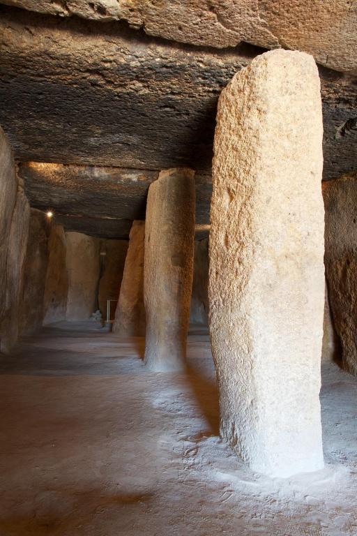 a cave with columns in a stone wall at Los Dólmenes in Antequera