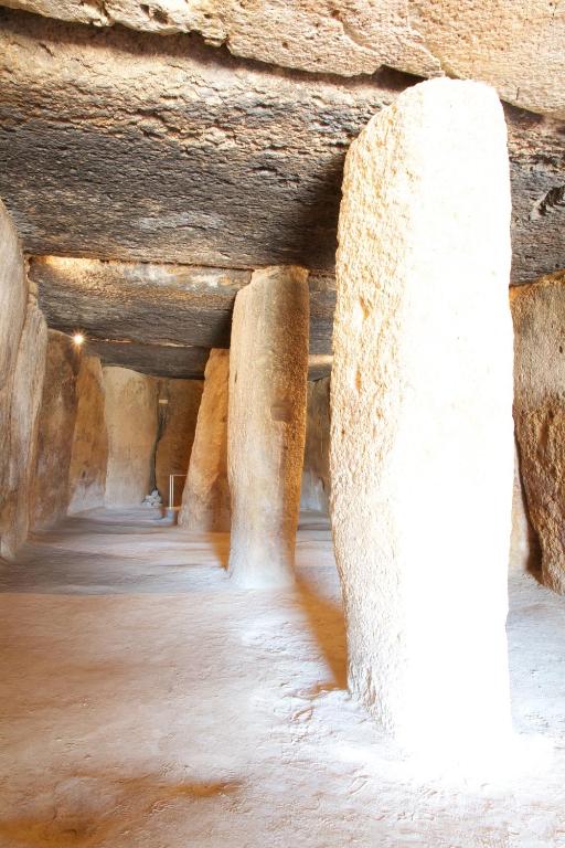 a cave with columns in a rock wall at Los Dólmenes in Antequera