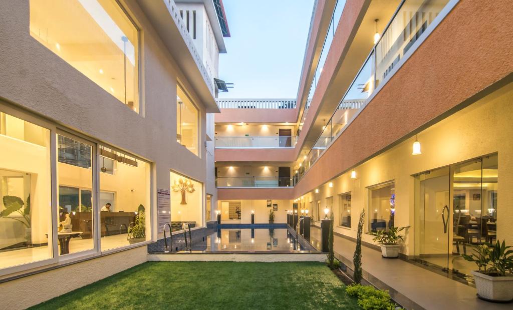 an indoor courtyard of a building with a lawn in the middle at Regenta Central North Goa, Arpora in Arpora