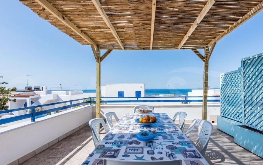 einen Tisch auf einem Balkon mit Meerblick in der Unterkunft Appartamento Da Maria in Torre Vado