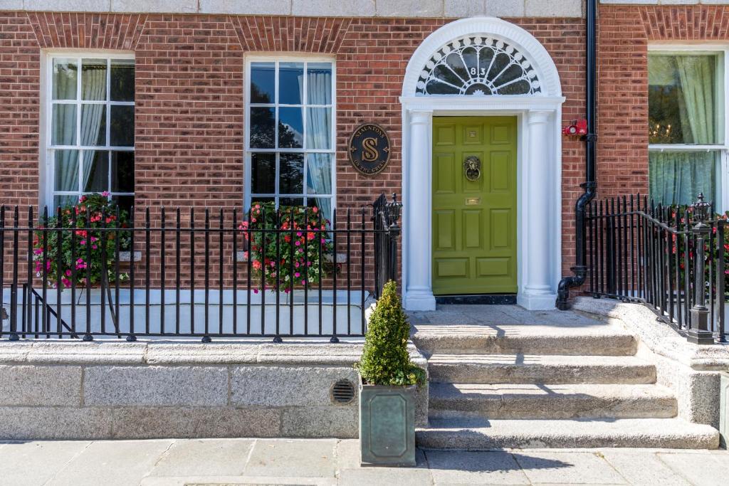 a green door on a brick building with stairs at Stauntons on the Green Hotel in Dublin