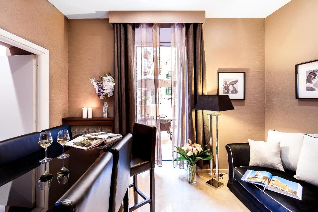 een woonkamer met een bank en een tafel met wijnglazen bij The Brunetti - Luxury serviced apartment in Rome