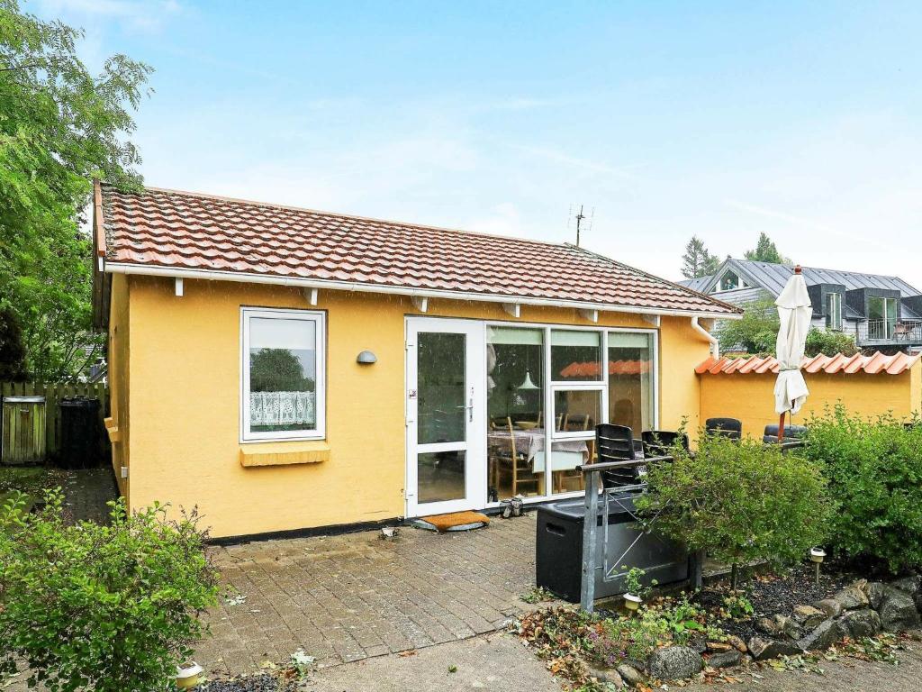 uma casa amarela com uma grande porta de vidro deslizante em 4 person holiday home in Nyk bing M em Refshammer