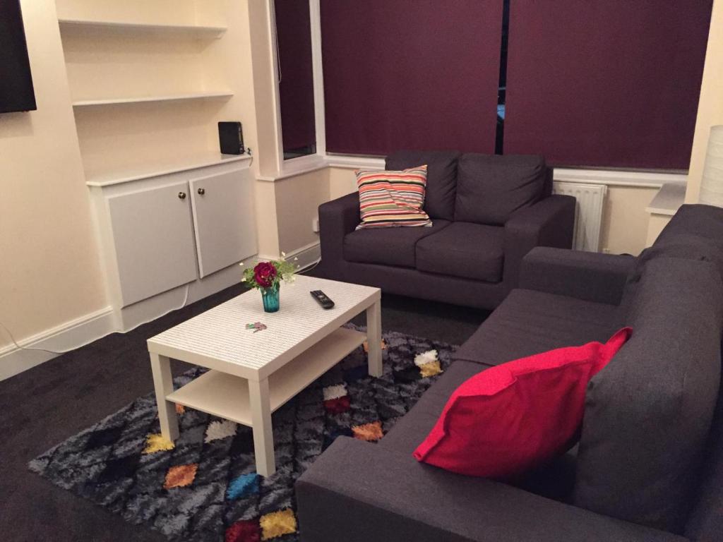 ein Wohnzimmer mit einem Sofa und einem Couchtisch in der Unterkunft Marble Apartments Tooting House in London