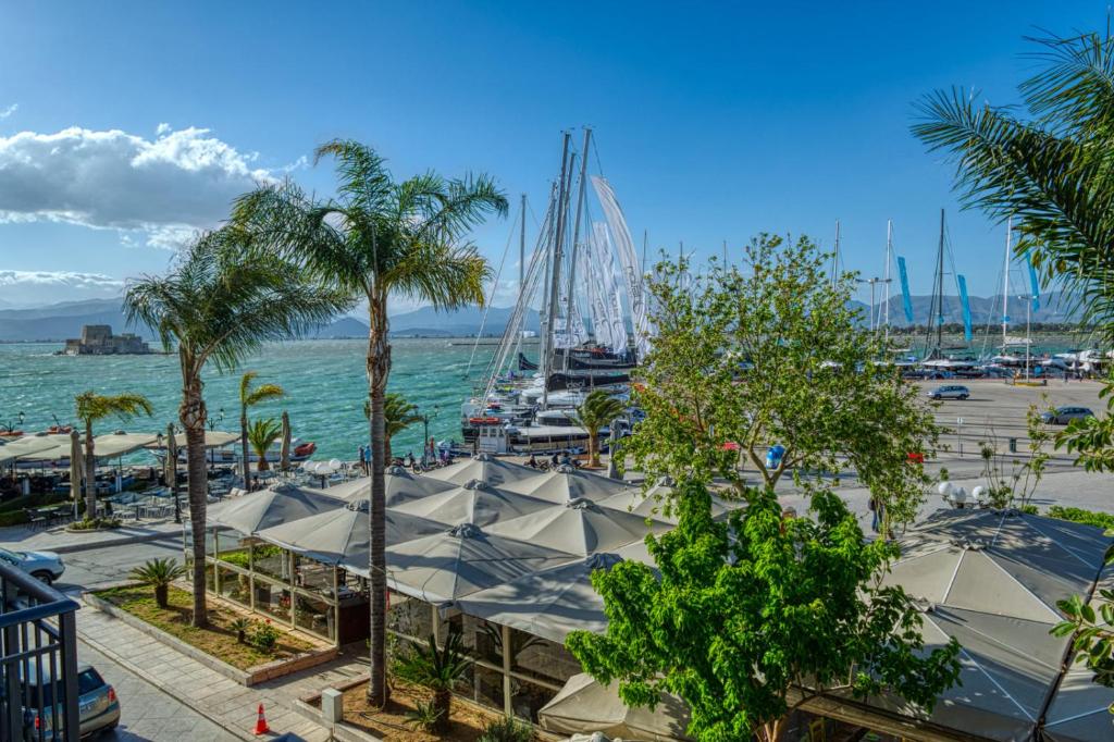 a marina with boats in the water and palm trees at Plaza Filellinon in Nafplio