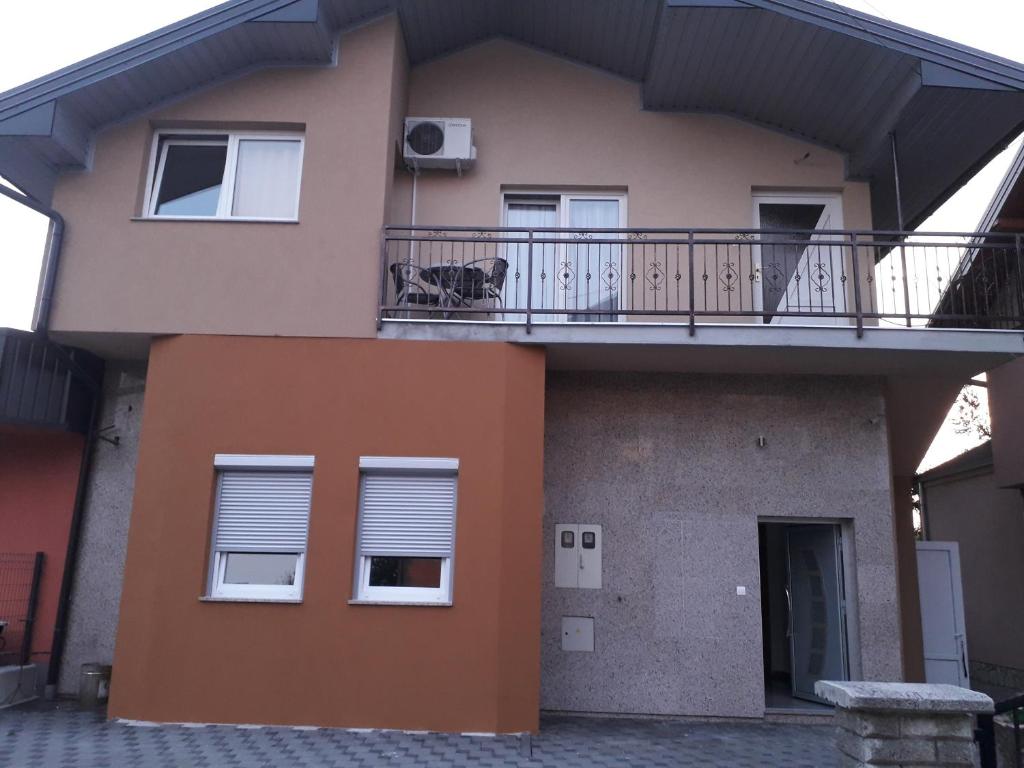 a house with a balcony and a dog on the porch at Biser-Hatinac in Bihać