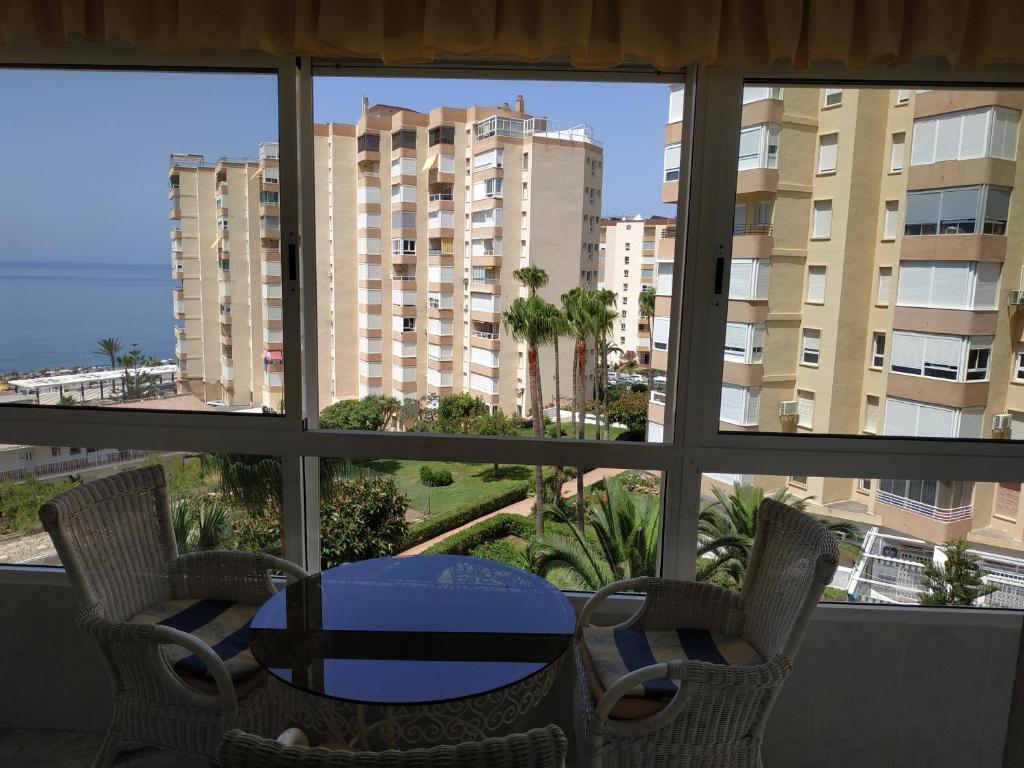 a table and chairs in a room with a window at Apartamento Torrox Costa in Torrox Costa